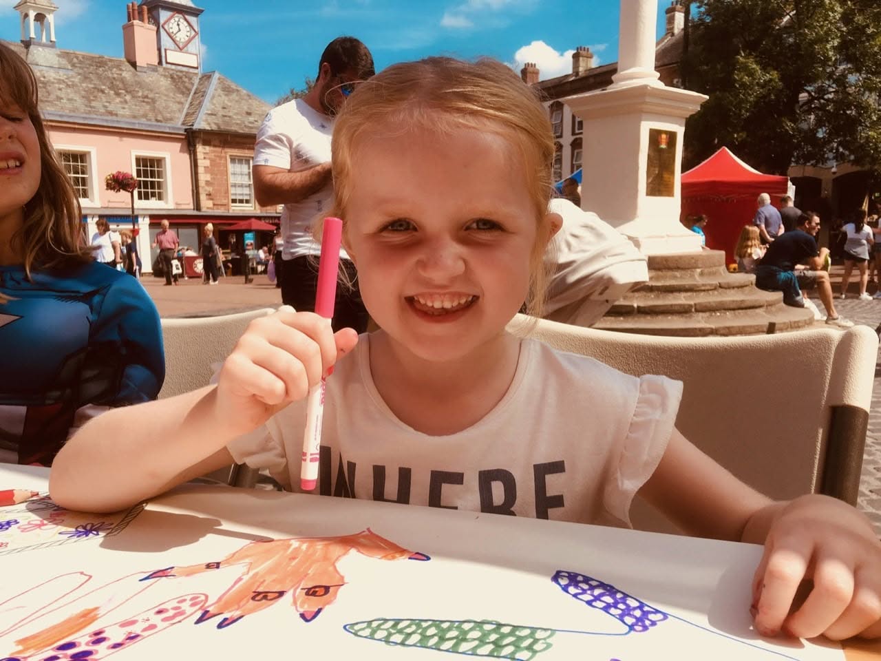 Smiling girl drawing in the sunshine